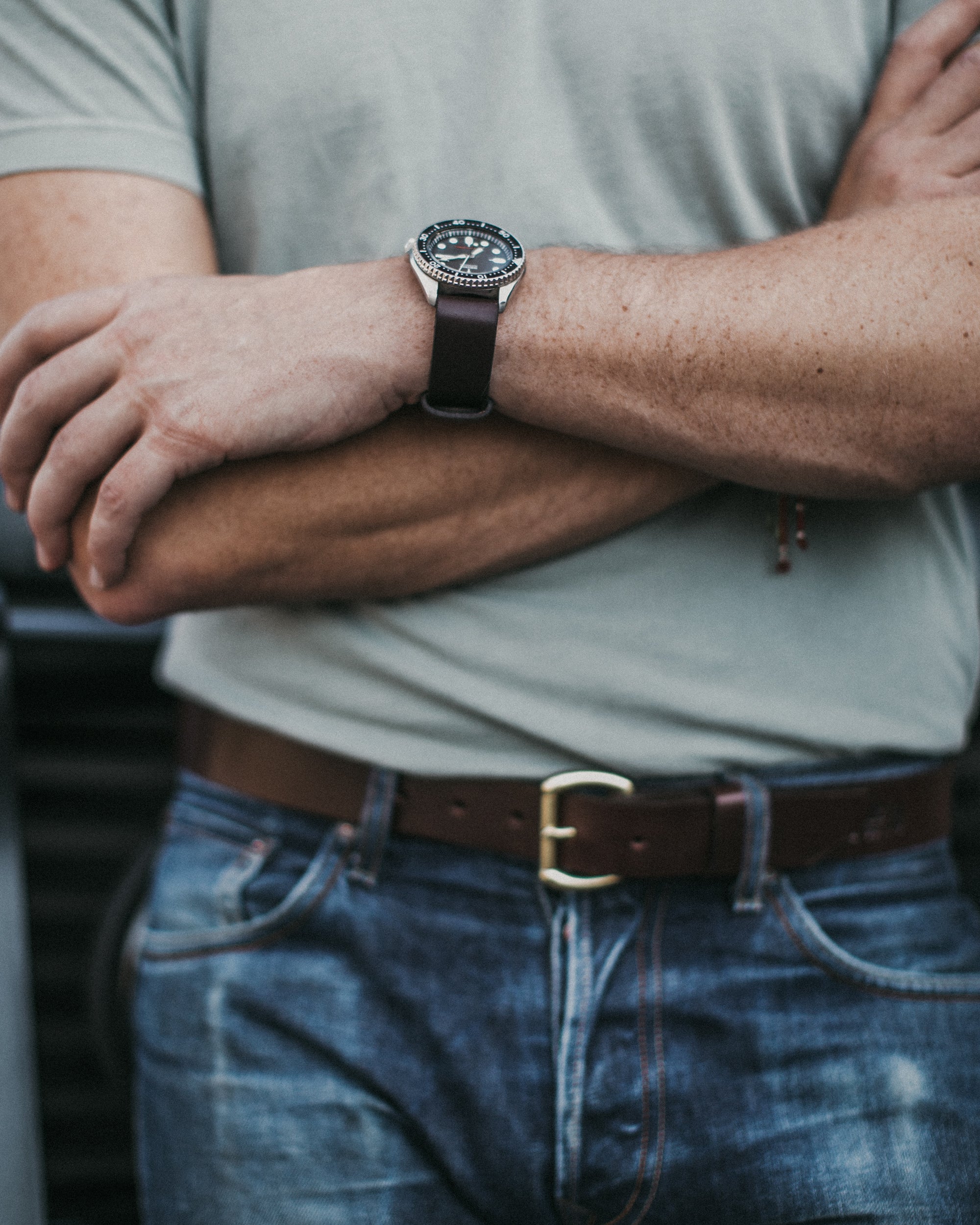 Dark brown leather belt featuring brass buckle