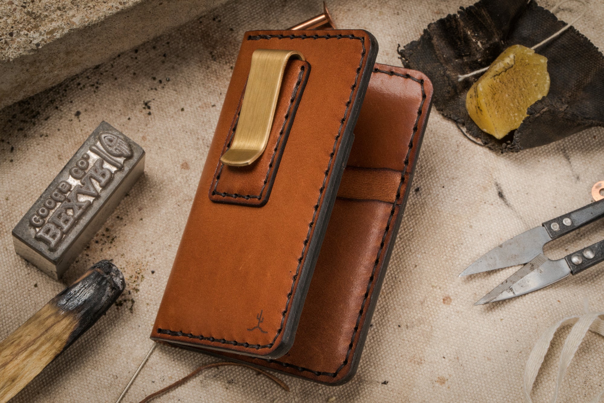 brown leather four pocket vertical wallet with brass money clip on exterior