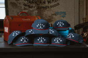 Blue Bexar Cap front view on a wooden table, showcasing the Bexar Goods logo patch